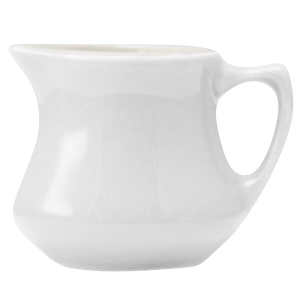 A Hall China ivory creamer with a handle.