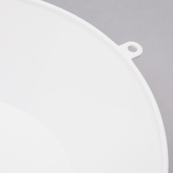 A white plastic scoop with a curved surface and a hole in the handle.