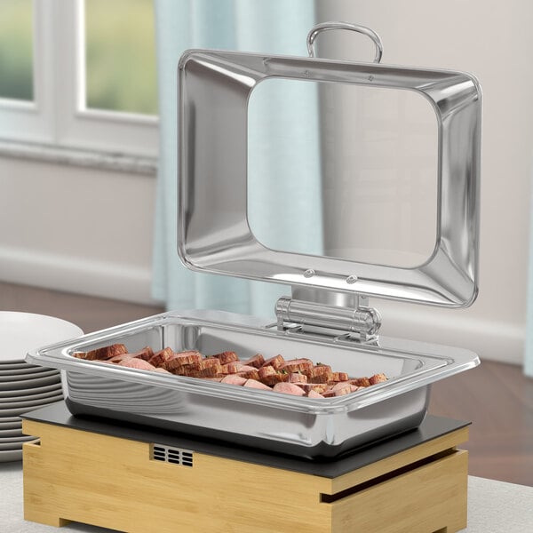 An Acopa stainless steel chafer with food in it on a table.