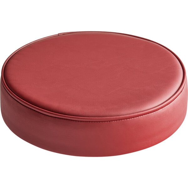 A round maroon vinyl seat cushion for a bar stool.