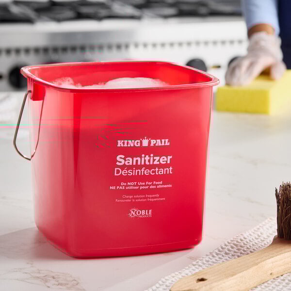 A red Noble King-Pail 6 quart sanitizing pail with a metal handle and printed labeling.
