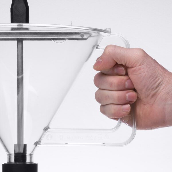 A hand holding a clear polycarbonate funnel with a metal stand.