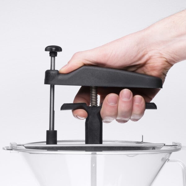 A hand using the Matfer Bourgeat Polycarbonate Portion Control Funnel with a black device.