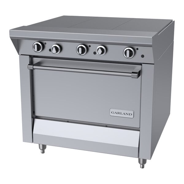 A stainless steel commercial hot top range with four control knobs and a standard oven, branded Garland.