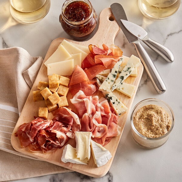 A standard charcuterie board with meat, cheese, and dips