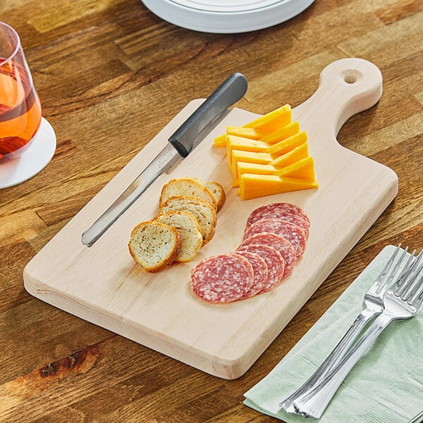 A Choice wooden serving and cutting board with a knife slot holding sliced cheese.