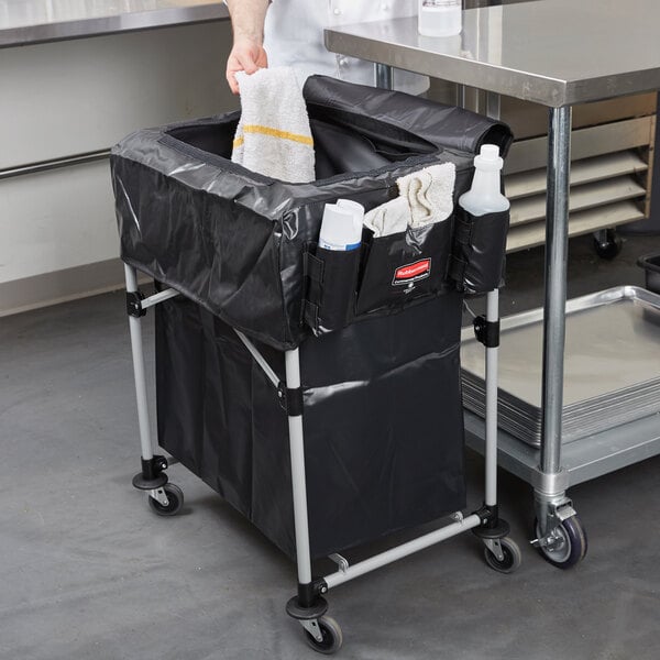 A person holding a white towel in a black bag on a metal frame.