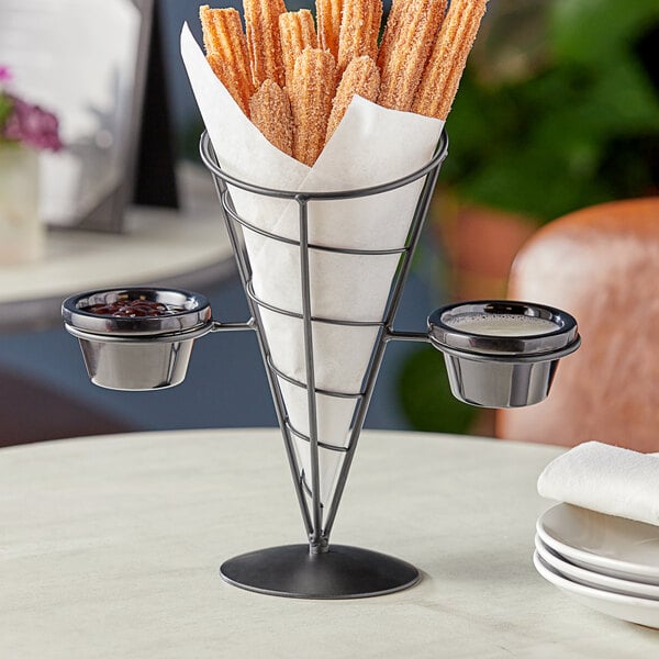 A black metal wire cone basket with 2 white ramekins.