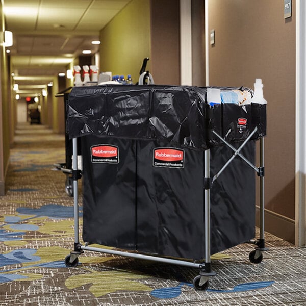 A black Rubbermaid laundry cart with a black cover on it.