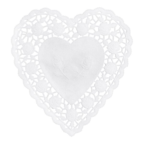 A white, heart-shaped paper doily with a lacy, floral cutout pattern and embossed roses in the center.