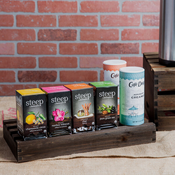 A wooden crate filled with boxes of chamomile tea on a wooden stand.
