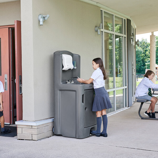 Two children washing hands at a Crown Verity portable hand sink.