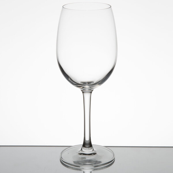A close-up of a clear Reserve by Libbey wine glass on a reflective surface.