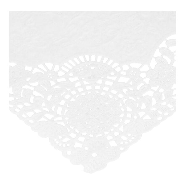 A close-up view of a white paper placemat with an intricate floral lace pattern and cut-out details.