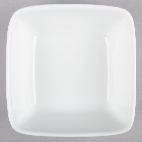 A white square bowl on a gray surface.