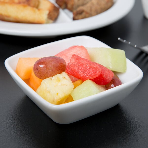 A Libbey white porcelain square bowl filled with a close up of fruit.