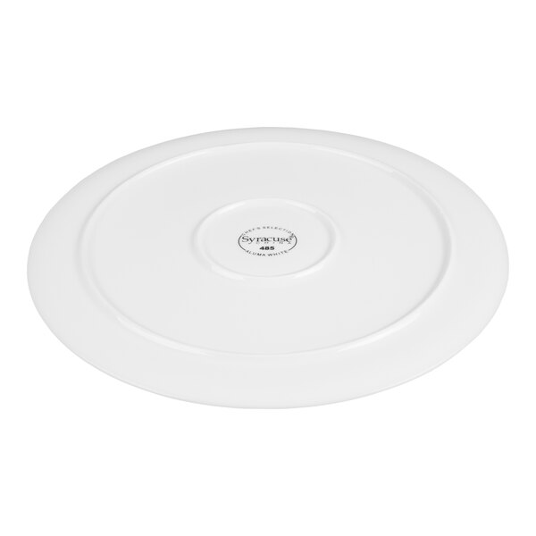 A white, round porcelain tray with a slightly raised rim and a central logo on the bottom.