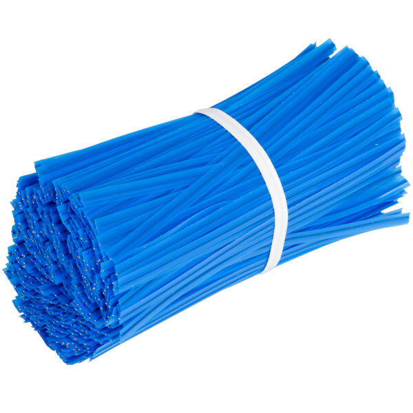 A pile of blue plastic cable ties on a blue and white Manitowoc ice bagger.