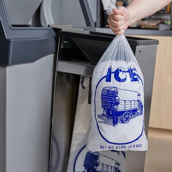 A person using a Manitowoc stainless steel ice bagger to fill a plastic bag with ice.
