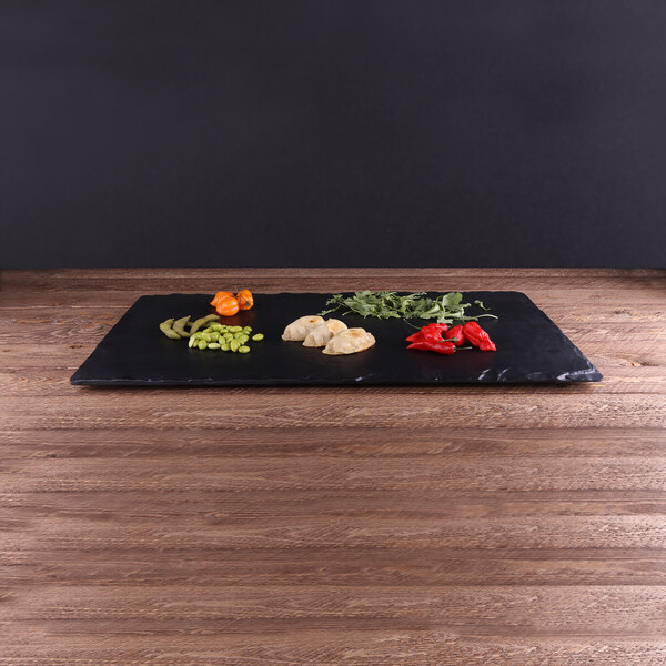 a black plate with vegetables on it
