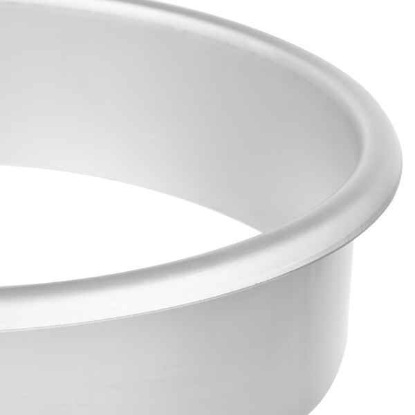 A silver round stainless steel in-counter trash chute.