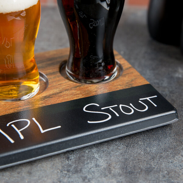 A Cal-Mil faux wood tray with two glasses of beer on it.