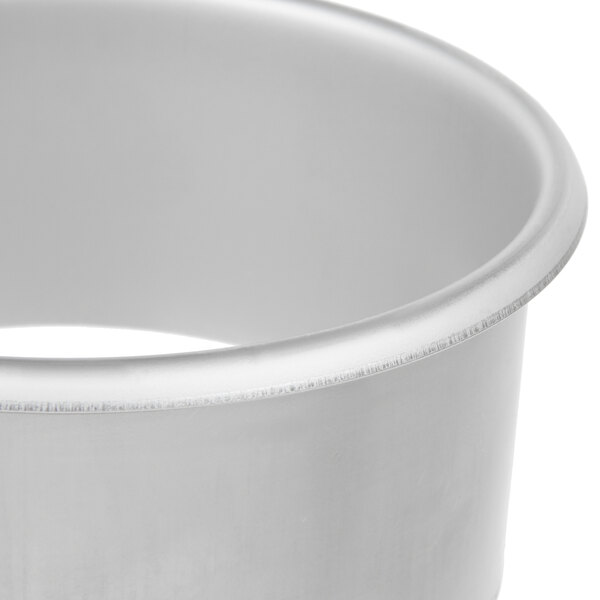 A close-up of a silver Vollrath stainless steel round in-counter trash chute.