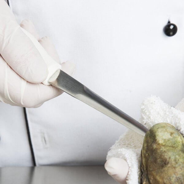 A gloved hand uses a Dexter Russell 4" oyster knife to shuck an oyster.