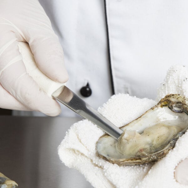 A person using a Dexter Russell Boston Style Oyster Knife to cut an oyster.
