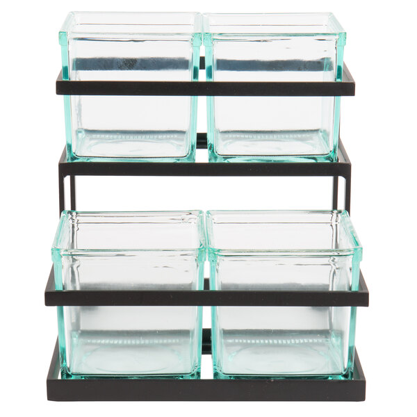 A black metal rack holding three square glass containers with black lids.
