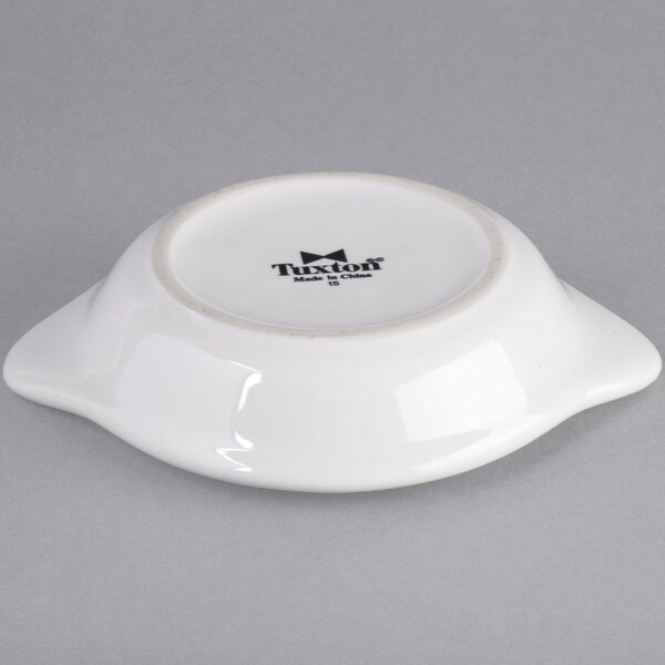 A white round Tuxton china shirred egg dish.