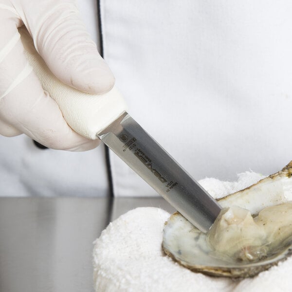 A person in a white glove using a Dexter Russell oyster knife to open an oyster.