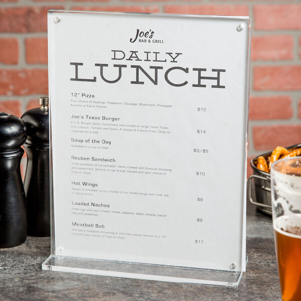 A clear Cal-Mil card holder with a menu on a table.