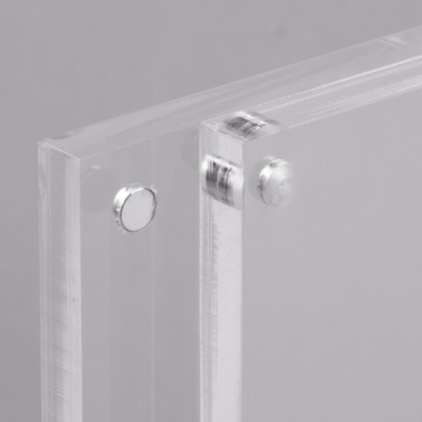A close-up of a clear plastic rectangular panel with a metal circle.
