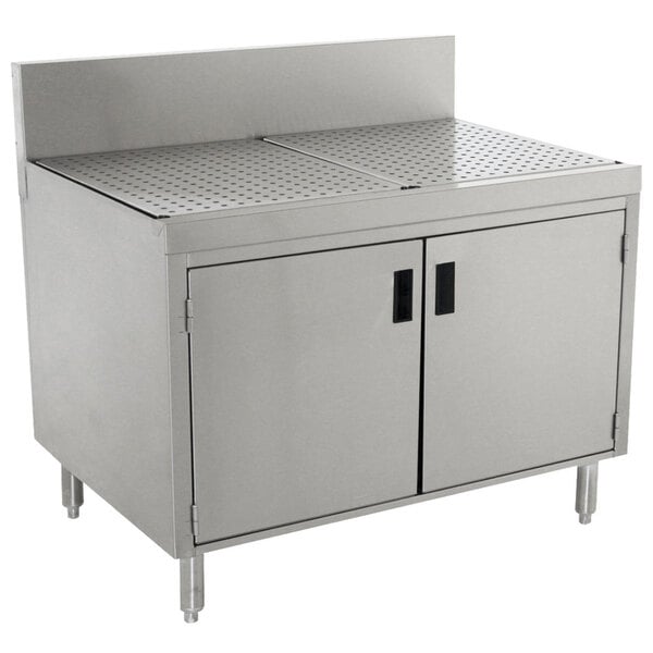 An Advance Tabco stainless steel drainboard cabinet with doors and a shelf over a stainless steel sink.