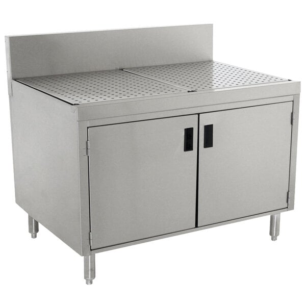 A stainless steel Advance Tabco drainboard cabinet with doors and a shelf over a sink.
