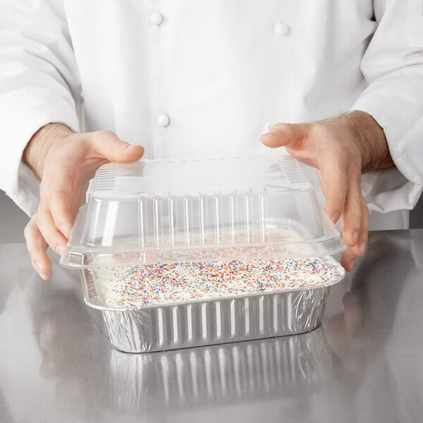 a container with white frosting and sprinkles