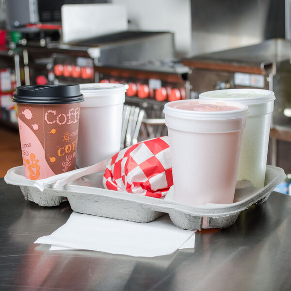 A Huhtamaki Chinet StrongHolder pulp fiber carrier with three white cups of coffee.