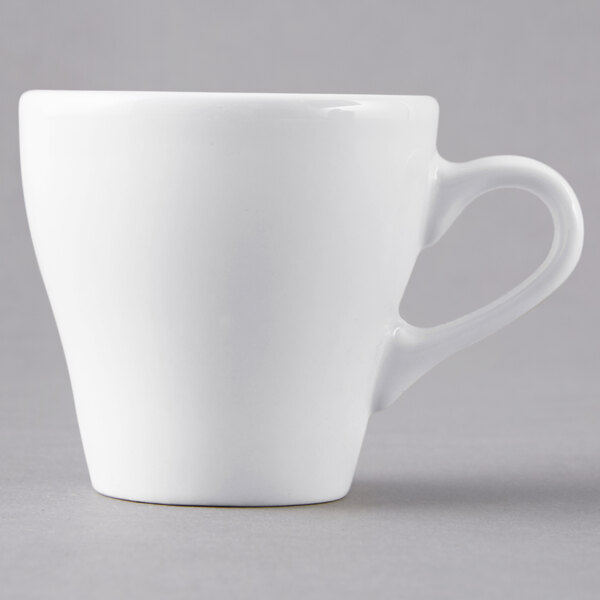 A close-up of a Tuxton white porcelain espresso cup with a handle.