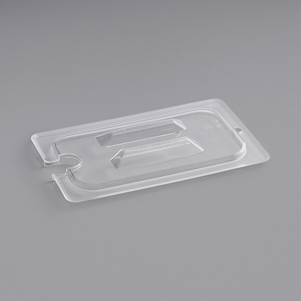 A clear plastic container lid with a spoon notch.