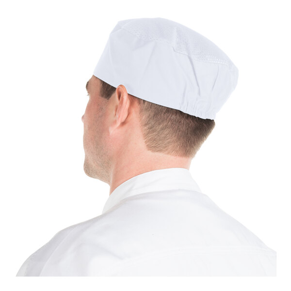 A person wearing a white cap and white clothing, viewed from behind.