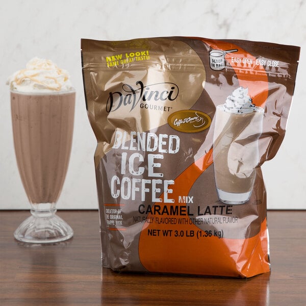 A bag of DaVinci Gourmet Caramel Latte Mix next to a glass of milk.