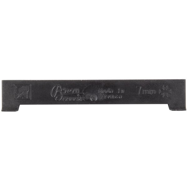 A black rectangular Bron Coucke cutting blade with writing on it.