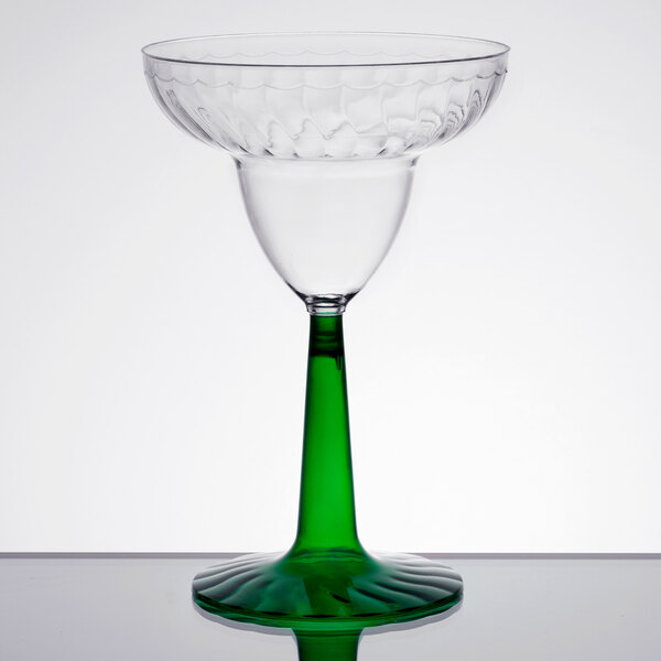 A clear plastic margarita glass with a green stem.