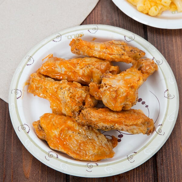 a plate of chicken wings and a plate of macaroni