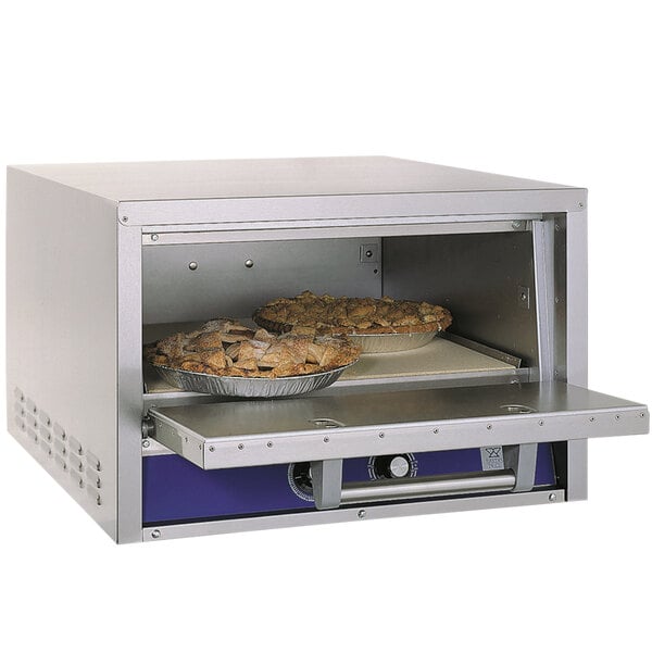 A Bakers Pride countertop oven with pies baking inside.