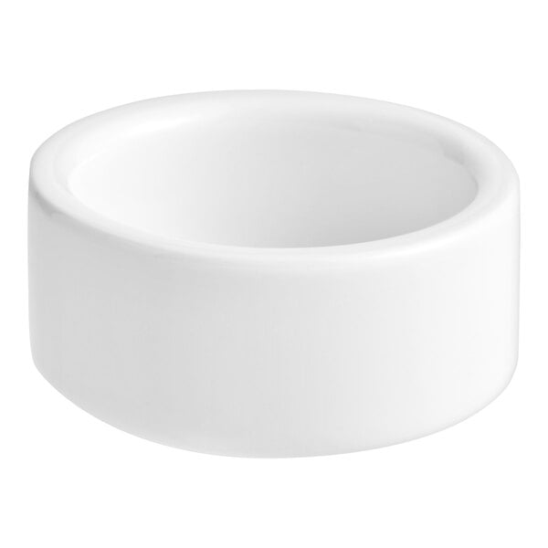 A small, round, white porcelain salt and pepper dish.