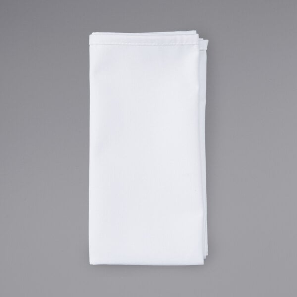 A folded white cloth napkin on a gray background.