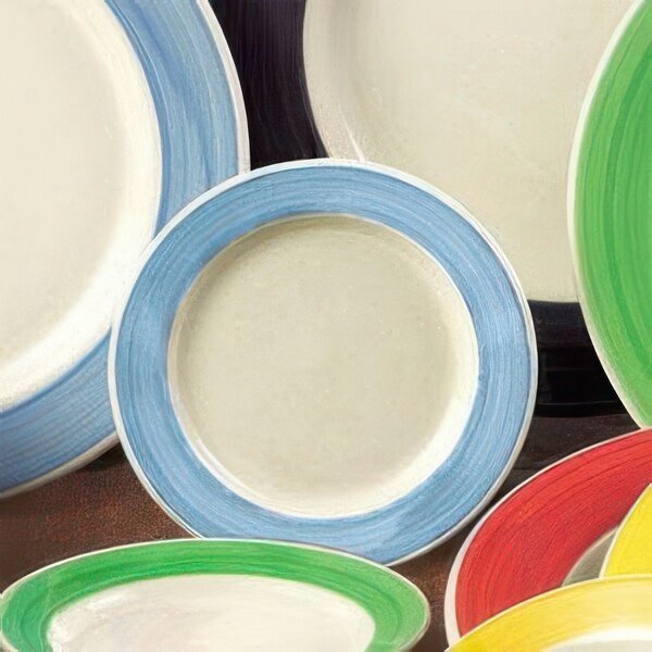 A close-up of a blue and white CAC stoneware bowl with a rainbow design.