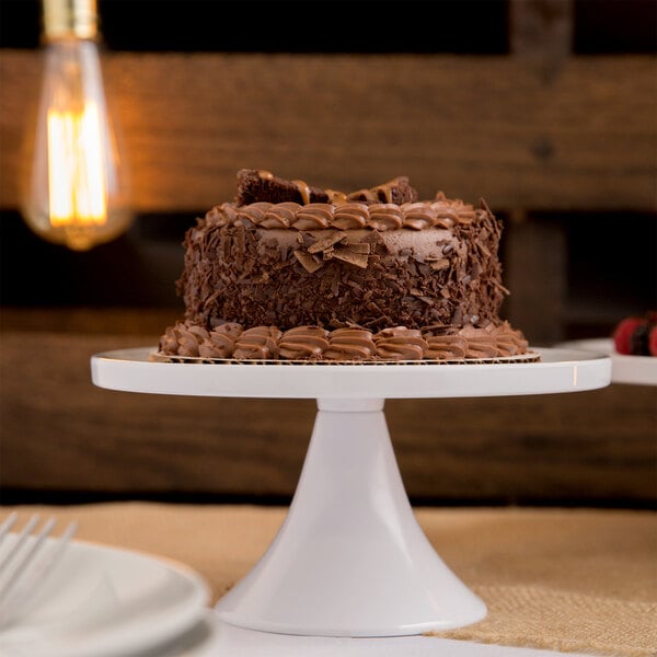 An Elite Global Solutions faux Carrara marble round plate stand with a chocolate cake on it.